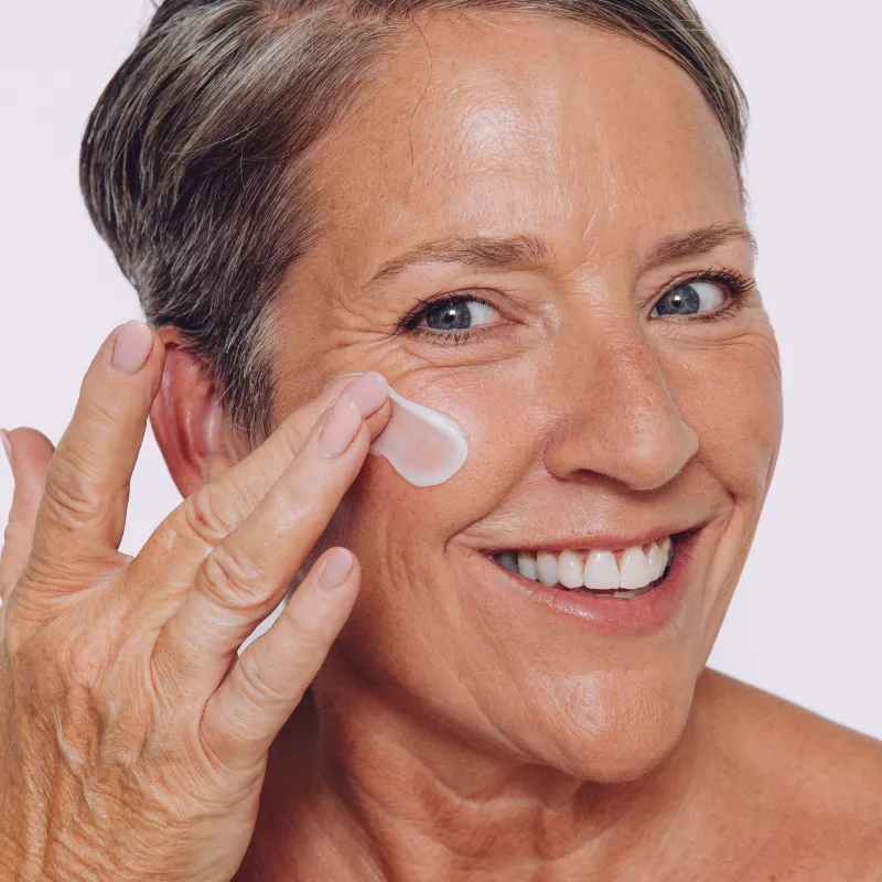 Model applying CellDerma COLLAGEN RESTORE Peptides and Resveratrol Anti-Aging Cream skincare product